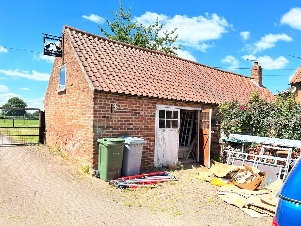 A blue car parked in front of a brick building.